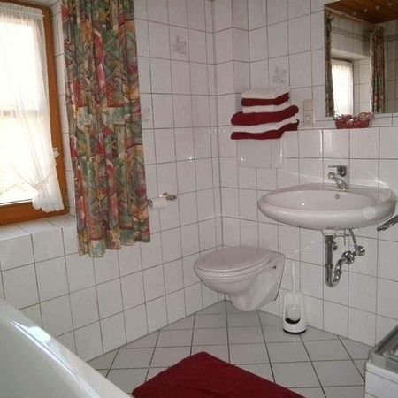 Weißes Badezimmer mit roten Akzenten